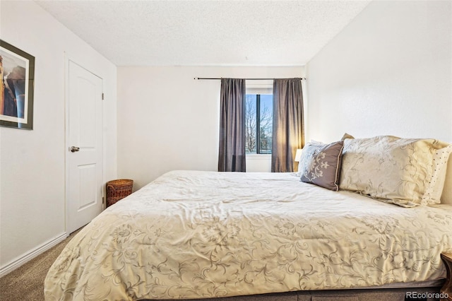 bedroom with a textured ceiling, carpet, and baseboards