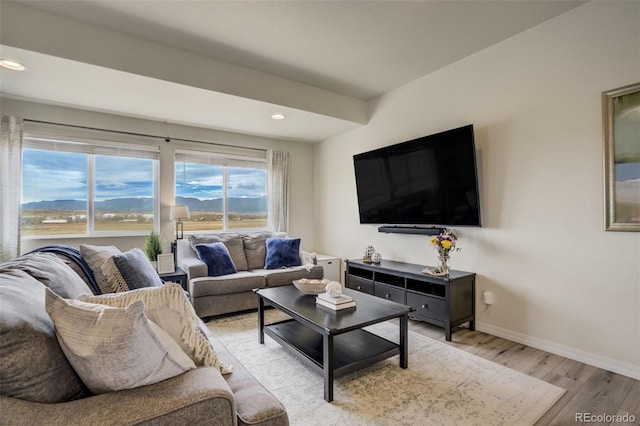 living room with recessed lighting, baseboards, and light wood finished floors