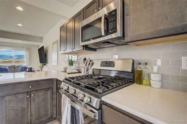kitchen with light countertops, dark brown cabinets, tasteful backsplash, and stainless steel appliances