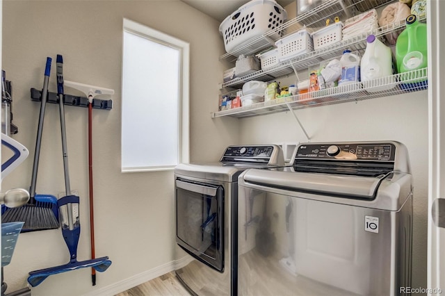 laundry room with laundry area, wood finished floors, baseboards, and washer and clothes dryer