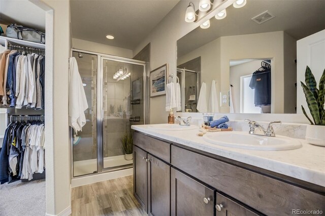 full bathroom featuring a sink, visible vents, a spacious closet, and a shower stall