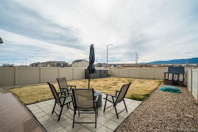 view of patio / terrace with a mountain view and a fenced backyard