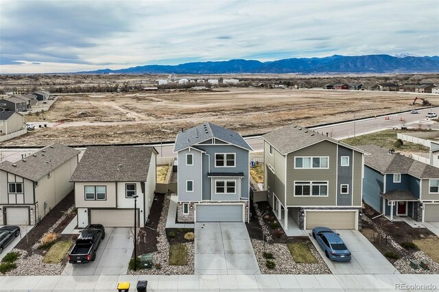 view of front facade featuring a mountain view, an attached garage, and a residential view