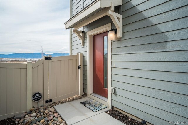 entrance to property with a mountain view, fence, and a gate