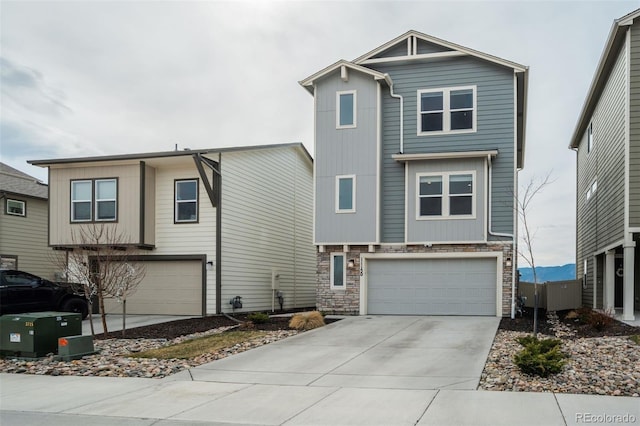 view of front of property featuring stone siding, driveway, and an attached garage