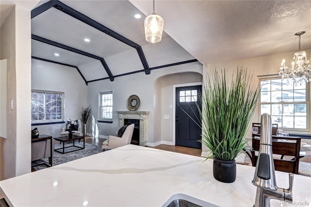 bedroom with vaulted ceiling, arched walkways, baseboards, wood finished floors, and a chandelier
