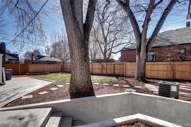 fenced backyard featuring cooling unit and a patio