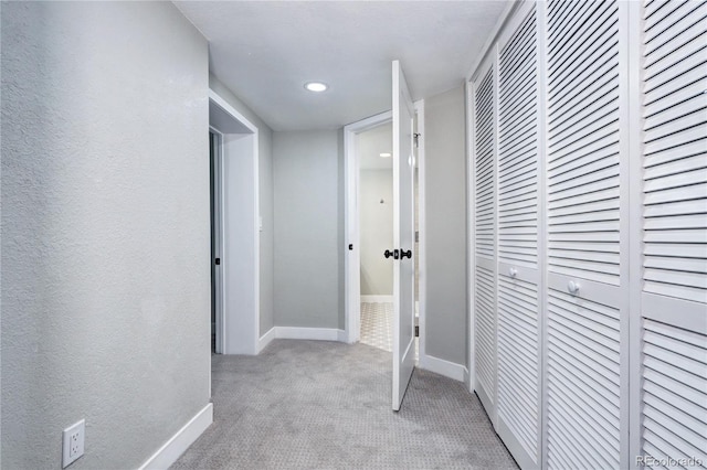 hall featuring carpet flooring, baseboards, and recessed lighting
