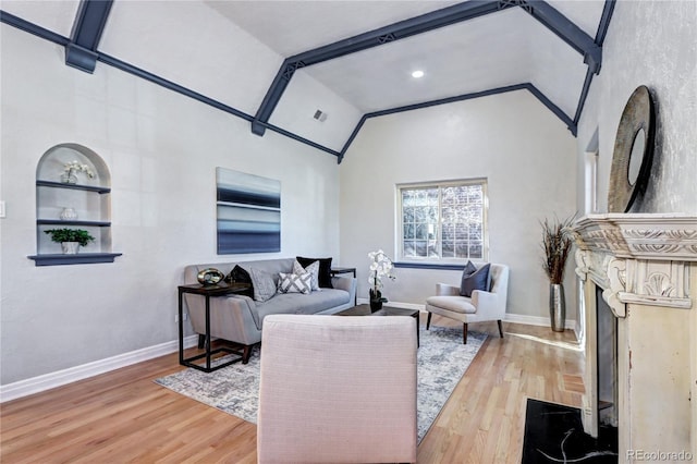 living room with lofted ceiling, wood finished floors, baseboards, and built in features