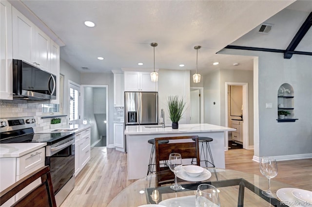 kitchen with stainless steel appliances, backsplash, light wood-style floors, a sink, and recessed lighting