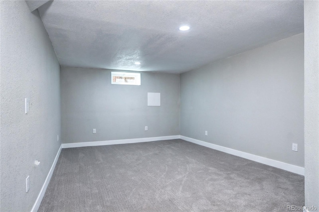 basement with dark colored carpet, a textured ceiling, baseboards, and recessed lighting