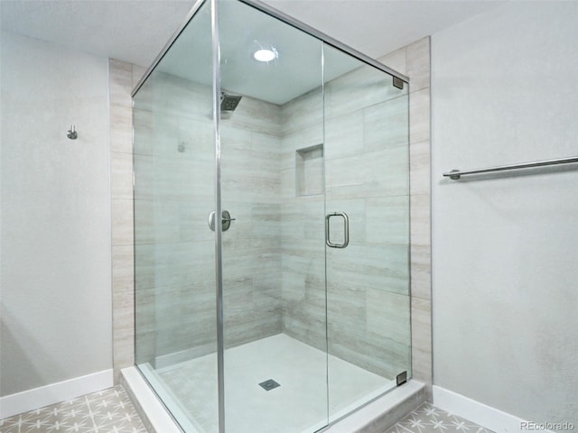 full bath featuring a shower stall and baseboards