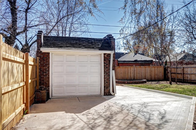 garage featuring driveway and fence