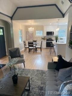 1378 Forest St, Denver, CO 80220 - living room with light wood-style floors, arched walkways, a chandelier, and high vaulted ceiling