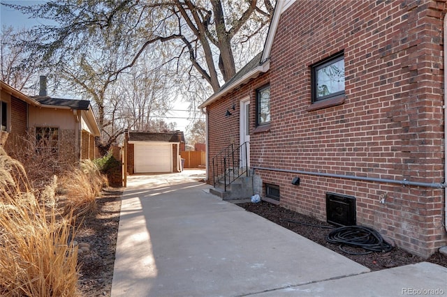 1378 Forest St, Denver, CO 80220 - view of property exterior with concrete driveway, entry steps, brick siding, and an outbuilding