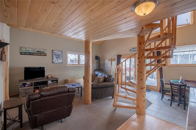 living room featuring a wood stove, light tile patterned flooring, and wooden ceiling