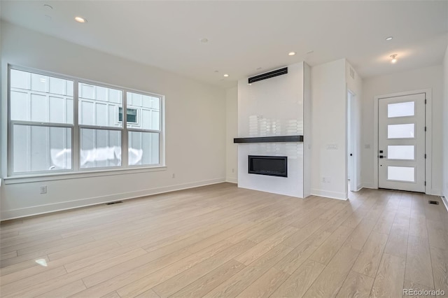 910 Promenade Dr, Superior, CO 80027 - unfurnished living room featuring a fireplace, light wood-type flooring, plenty of natural light, baseboards, and recessed lighting