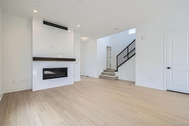 910 Promenade Dr, Superior, CO 80027 - unfurnished living room with stairs, a fireplace, light wood finished floors, baseboards, and recessed lighting