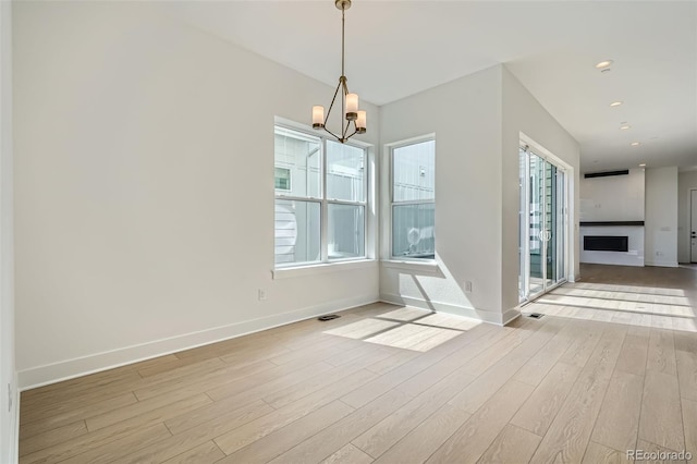 910 Promenade Dr, Superior, CO 80027 - unfurnished dining area featuring light wood-style floors, baseboards, a chandelier, a fireplace, and recessed lighting