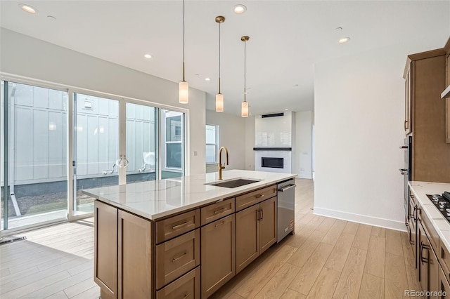 910 Promenade Dr, Superior, CO 80027 - kitchen featuring a sink, light wood-style floors, dishwasher, an island with sink, and decorative light fixtures