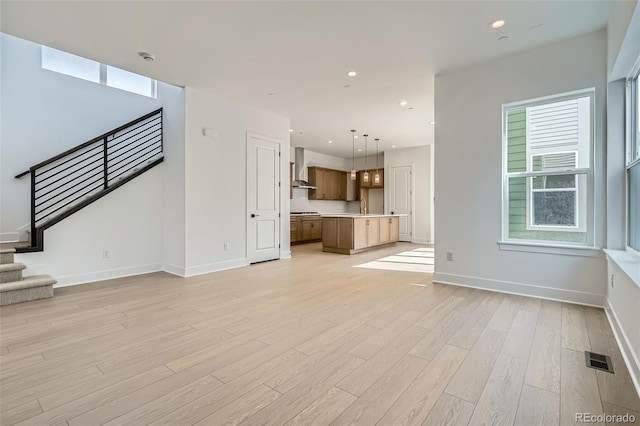 910 Promenade Dr, Superior, CO 80027 - unfurnished living room with stairs, light wood-style floors, a sink, baseboards, and recessed lighting