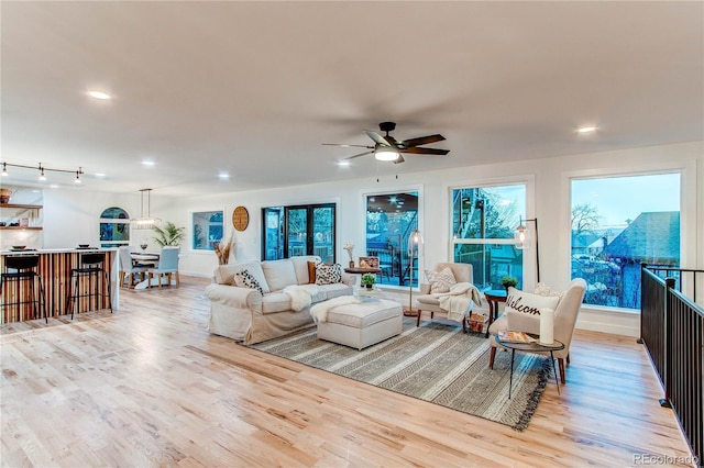 living room with ceiling fan and light hardwood / wood-style floors