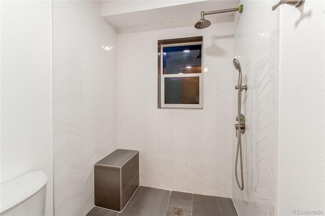 bathroom featuring toilet and a tile shower