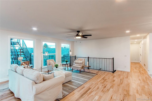 living room featuring ceiling fan and light wood-type flooring