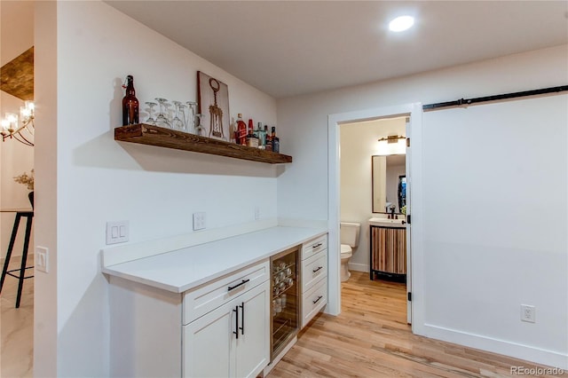 kitchen featuring white cabinetry, light hardwood / wood-style flooring, and a chandelier