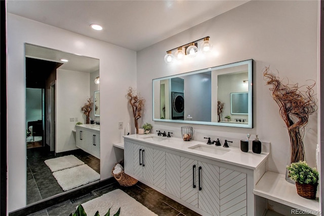 bathroom featuring stacked washer / dryer, tile patterned floors, and vanity