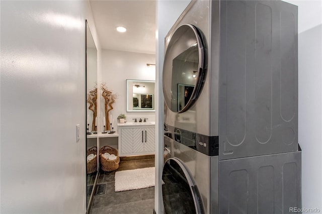 laundry room featuring stacked washing maching and dryer and sink