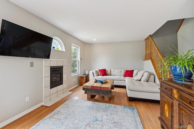 943 Reynolds Farm Ln Unit D8, Longmont, CO 80503 - living area with light wood-style floors, stairway, and a tiled fireplace