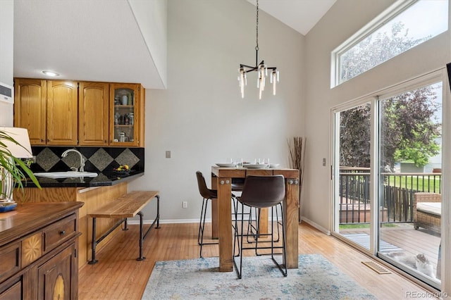 943 Reynolds Farm Ln Unit D8, Longmont, CO 80503 - dining space featuring a chandelier, light wood finished floors, and high vaulted ceiling
