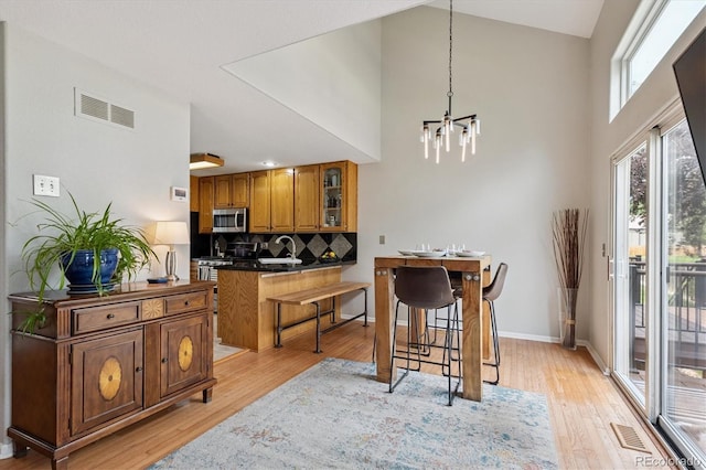 943 Reynolds Farm Ln Unit D8, Longmont, CO 80503 - dining area featuring a high ceiling, a chandelier, and light wood finished floors
