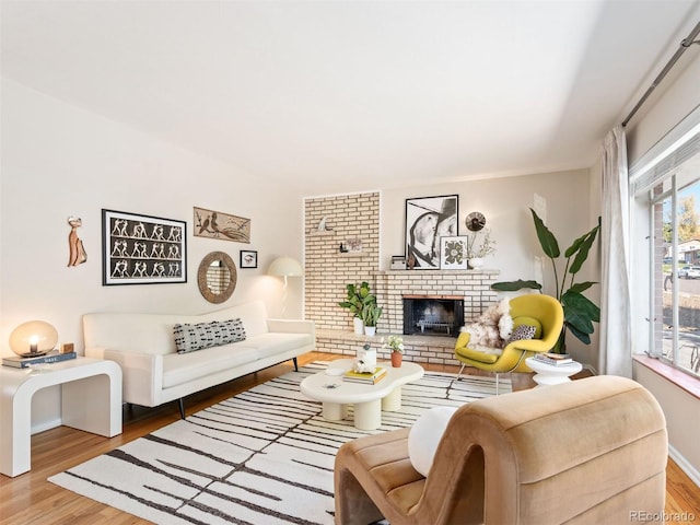 living room featuring hardwood / wood-style floors and a brick fireplace