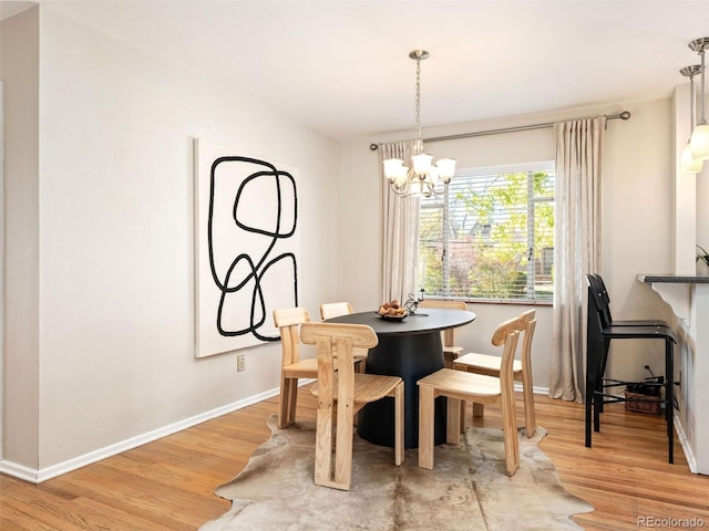 dining space with an inviting chandelier and light hardwood / wood-style floors