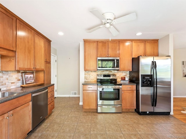 kitchen featuring appliances with stainless steel finishes, light tile patterned floors, and decorative backsplash