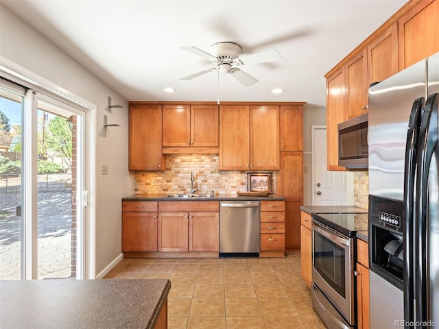 kitchen with sink, decorative backsplash, light tile patterned floors, ceiling fan, and stainless steel appliances