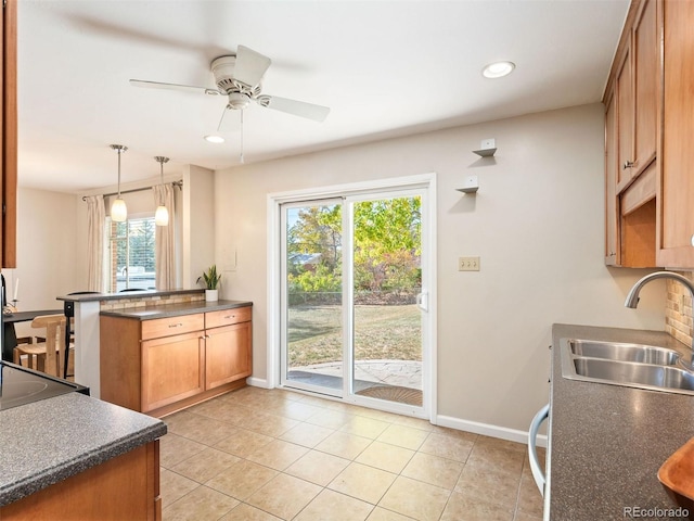 kitchen with sink, hanging light fixtures, light tile patterned floors, kitchen peninsula, and ceiling fan