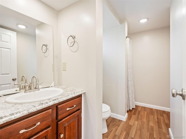 bathroom with a shower with curtain, vanity, toilet, and hardwood / wood-style floors