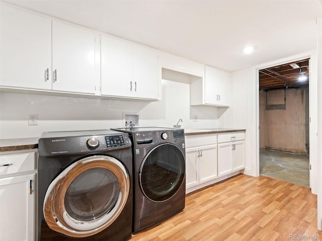 washroom featuring cabinets, light wood-type flooring, sink, and independent washer and dryer