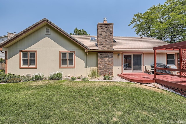 rear view of property with a yard and a wooden deck