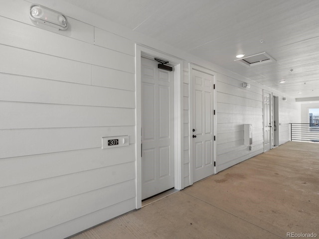 hallway featuring wooden walls