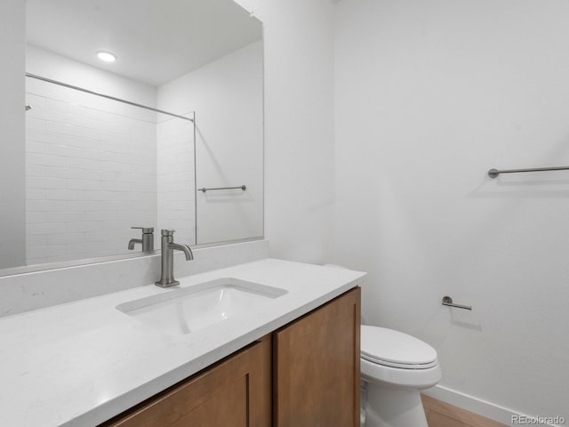 bathroom with baseboards, vanity, and toilet