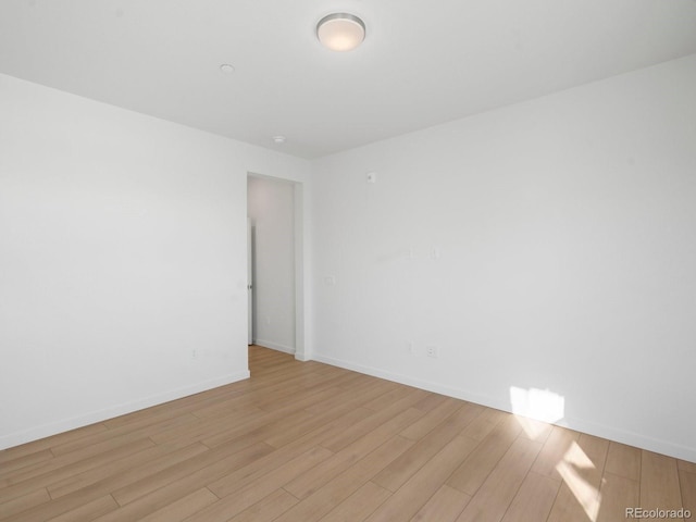 spare room with light wood-type flooring and baseboards