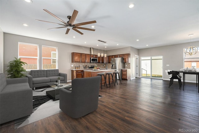 living room with recessed lighting, dark wood-style floors, and baseboards