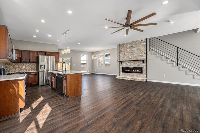 kitchen featuring light countertops, open floor plan, dark wood-type flooring, and stainless steel appliances