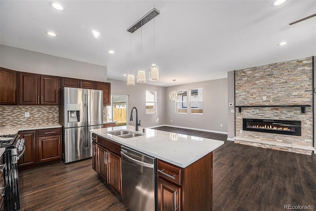 kitchen with dark wood finished floors, decorative backsplash, appliances with stainless steel finishes, and a sink