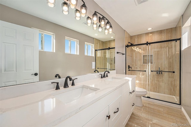 full bath featuring a shower stall, toilet, double vanity, and a sink