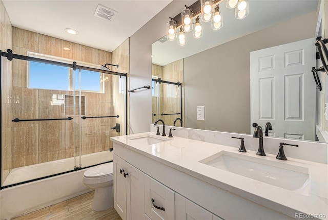 full bathroom with a sink, visible vents, enclosed tub / shower combo, and toilet